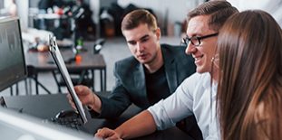 Holds Document In Hands. Team Of Stockbrokers Works In Modern Office With Many Display Screens